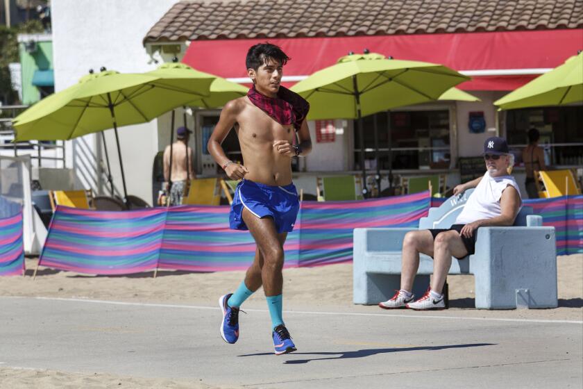 A man runs on the bike path at Will Rogers State Beach.