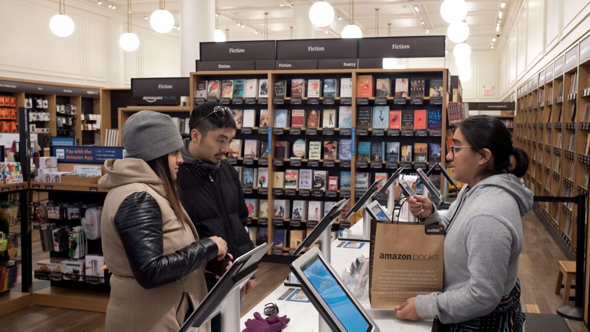 Customers make a purchase at an Amazon Books store in New York on Nov. 20, 2017. Amazon goes into the holiday season with a newly magnified brick-and-mortar presence.
