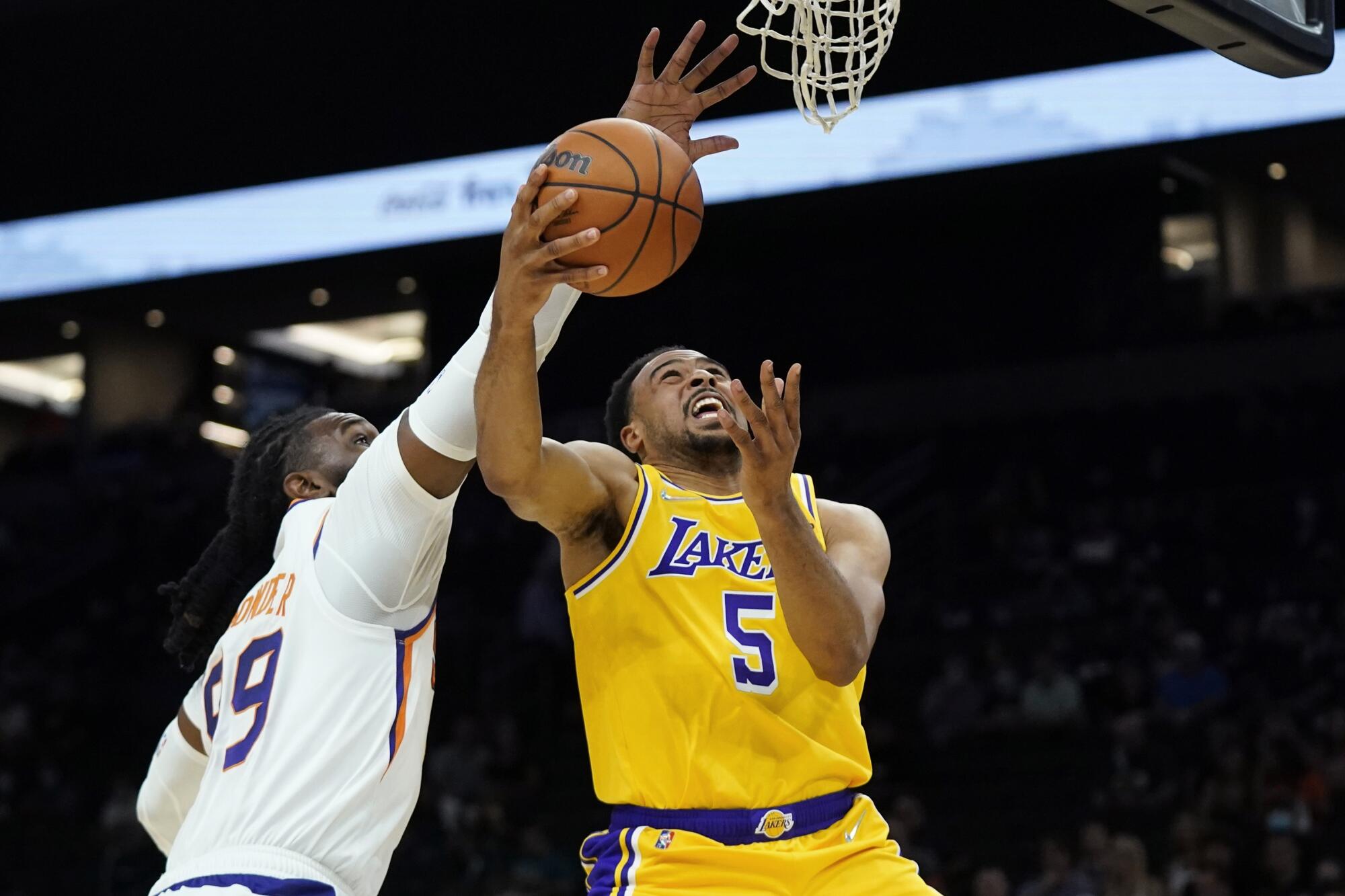 Lakers guard Talen Horton-Tucker (5) is fouled by Suns forward Jae Crowder while attempting a layup.