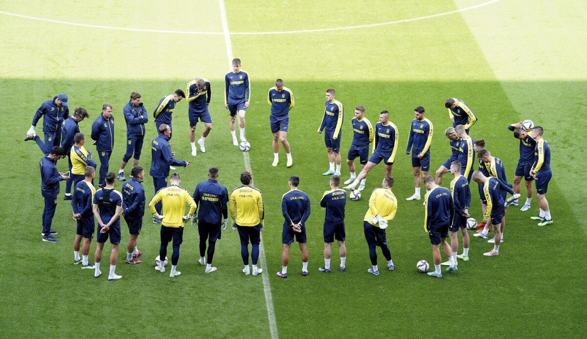 Ukraine players form a circle during a training session at the Cardiff City Stadium, Cardiff, Wales Saturday June 4, 2022, the day before the team play Wales in a World Cup play-off soccer match. (Mike Egerton/PA via AP)