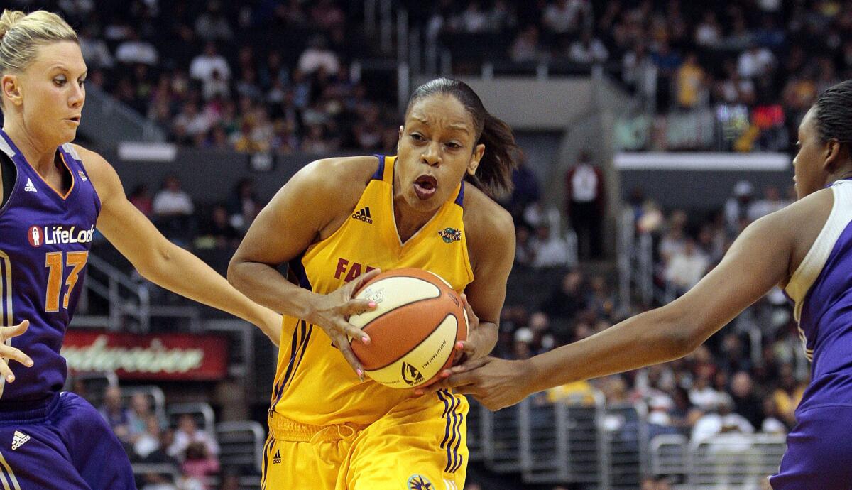 Sparks forward Tina Thompson drives to the basket against the Mercury's Penny Taylor, left, and Kara Braxton, during a WNBA game in 2011.