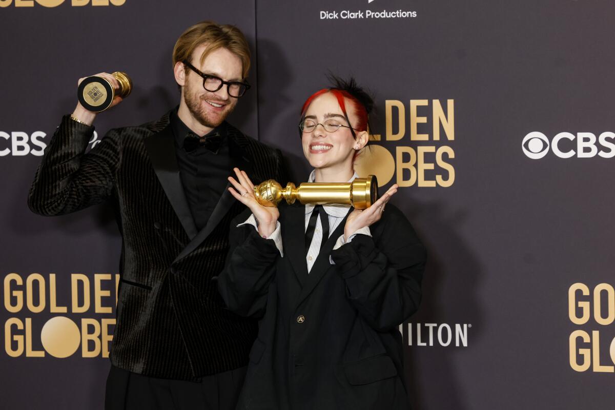 Musicians Billie Eilish and Finneas O'Connell pose with their Golden Globes for Best Original Song.