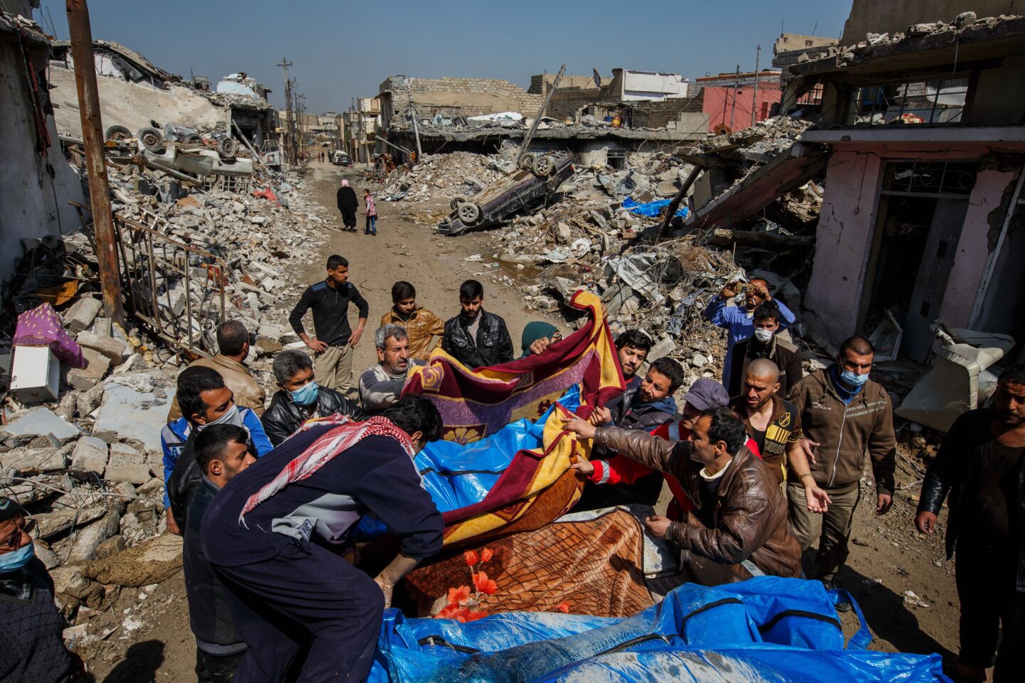 Residents pile body bags in the back of a truck after airstrikes in Mosul left scores dead.