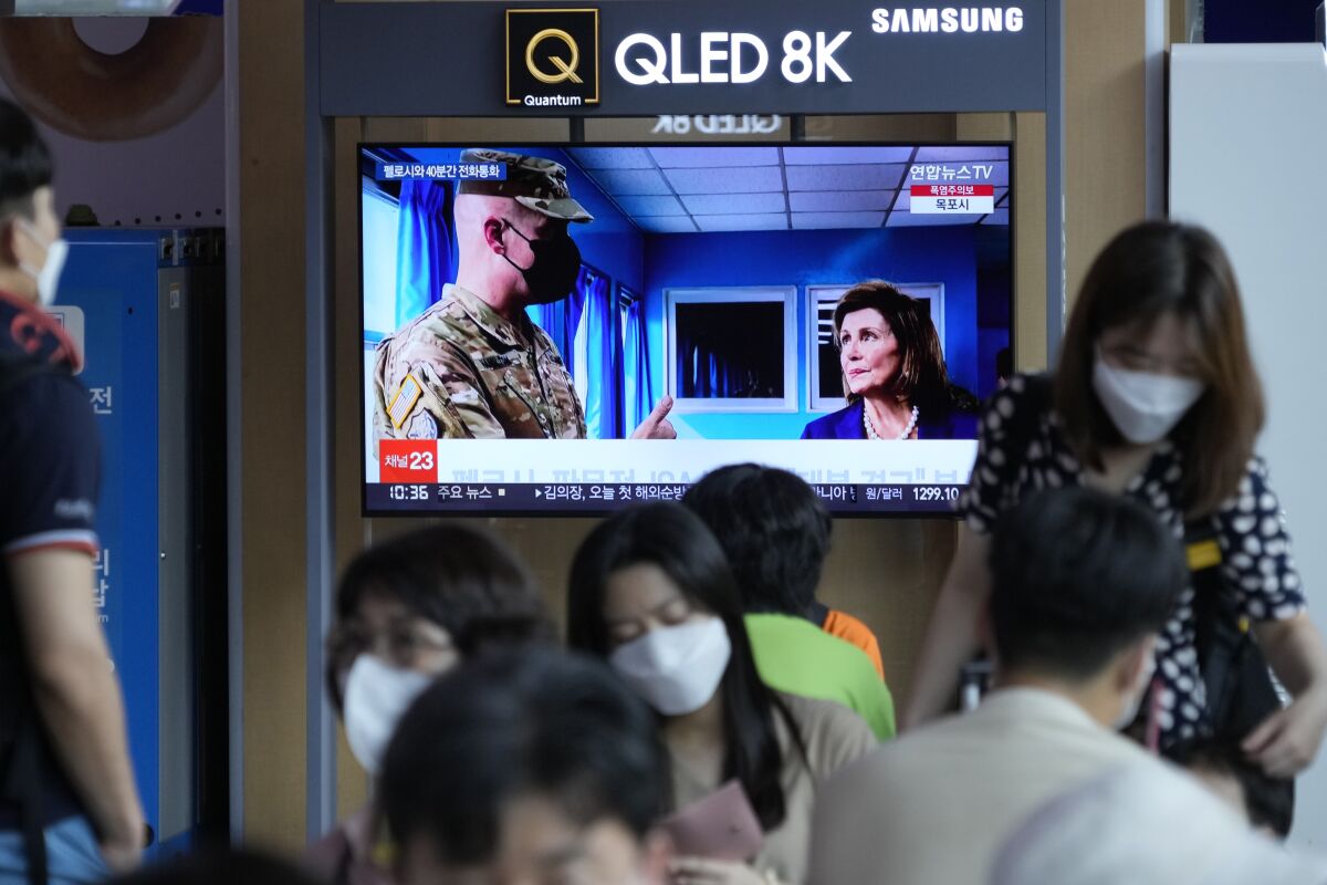 Una pantalla de televisión muestra un programa noticioso que reporta la visita de la presidenta 