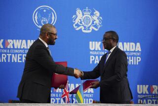 Britain's Home Secretary James Cleverly, left, and Rwandan Minister of Foreign Affairs Vincent Biruta shake hands after signing a new treaty in Kigali, Rwanda, Tuesday, Dec. 5, 2023. The treaty will address concerns by the Supreme Court, including assurances that Rwanda will not remove anybody transferred under the partnership to another country. (Ben Birchall/PA Wire via AP)