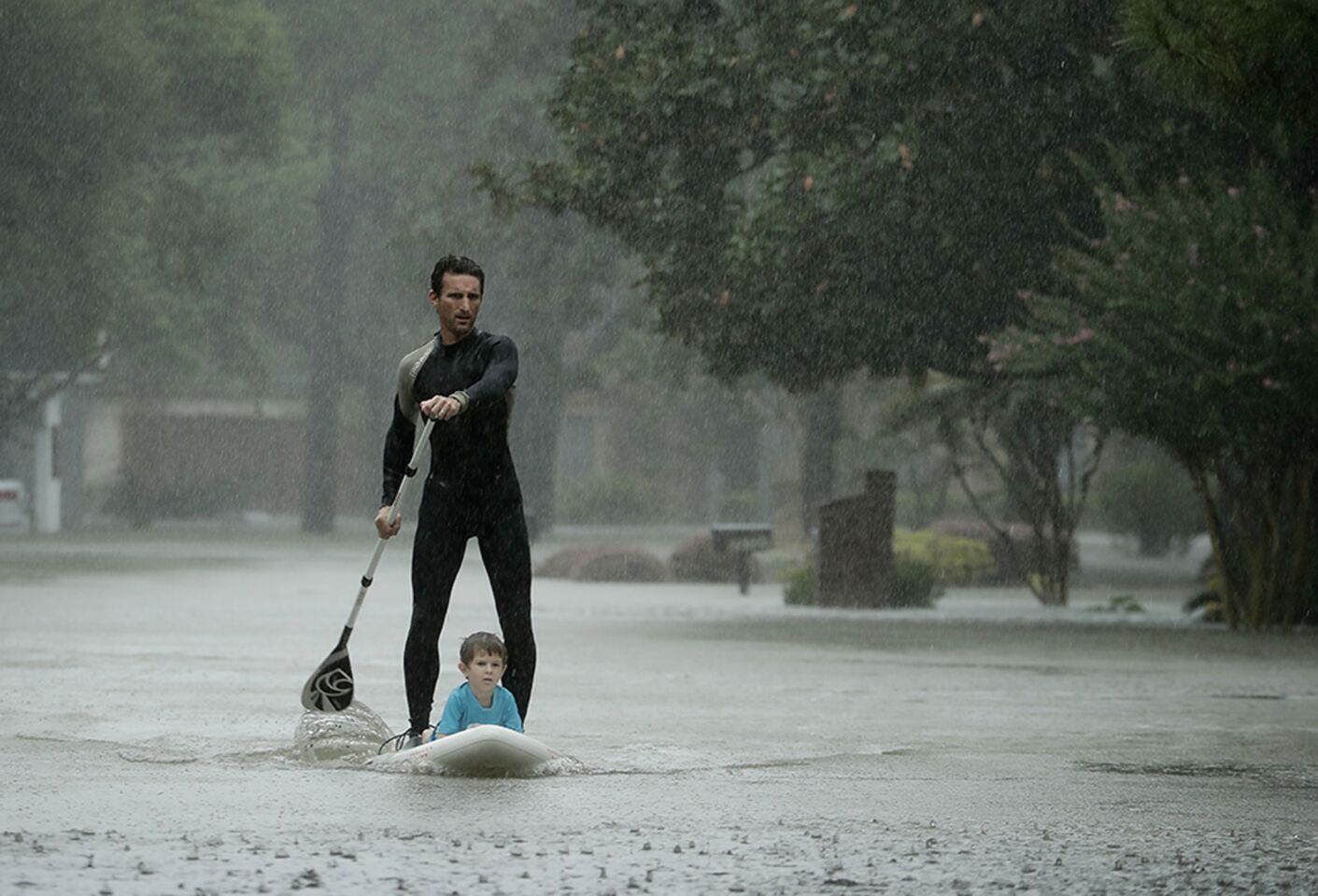 Alexendre Jorge evacuates Ethan Colman, 4, from a Houston neighborhood inundated by floodwaters from Tropical Storm Harvey.