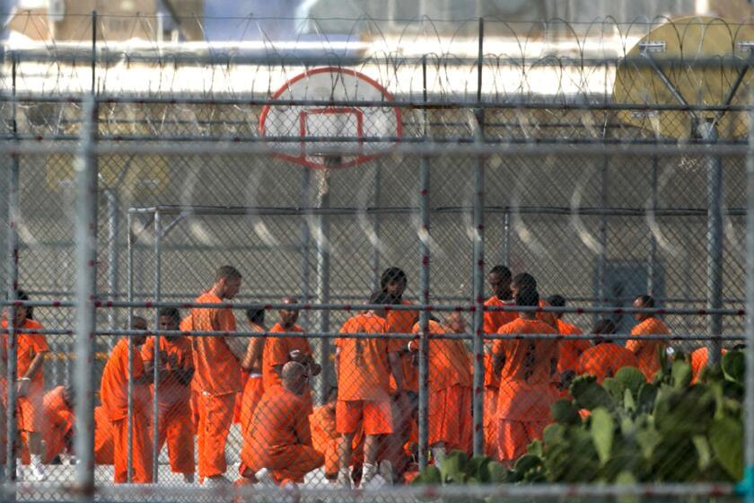 FILE - In this July 4, 2015, file photo, prison inmates stand in the yard at Arizona State Prison-Kingman in Golden Valley, Ariz. A book that discusses the impact of the criminal justice system on black men is being kept out of the hands of Arizona prison inmates. The American Civil Liberties Union is calling on the Arizona Department of Corrections to rescind a ban on "Chokehold: Policing Black Men." (Patrick Breen/The Arizona Republic via AP, File)