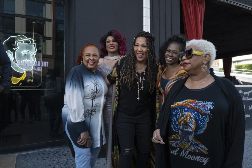 Five women smile posing for a picture