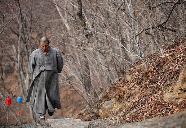 Buddhist monk Ando strolls along a mountain path near the temple.