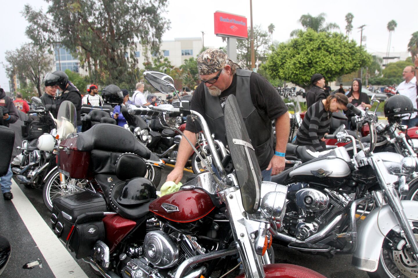 With a steady drizzle coming down, Tim Teaters of Modesto wipes rain off his motorcycle prior to the start of the 32nd annual Love Ride at Harley-Davidson Motorcycles in Glendale on Sunday, October 18, 2015. This will be the last fundraising Love Ride.
