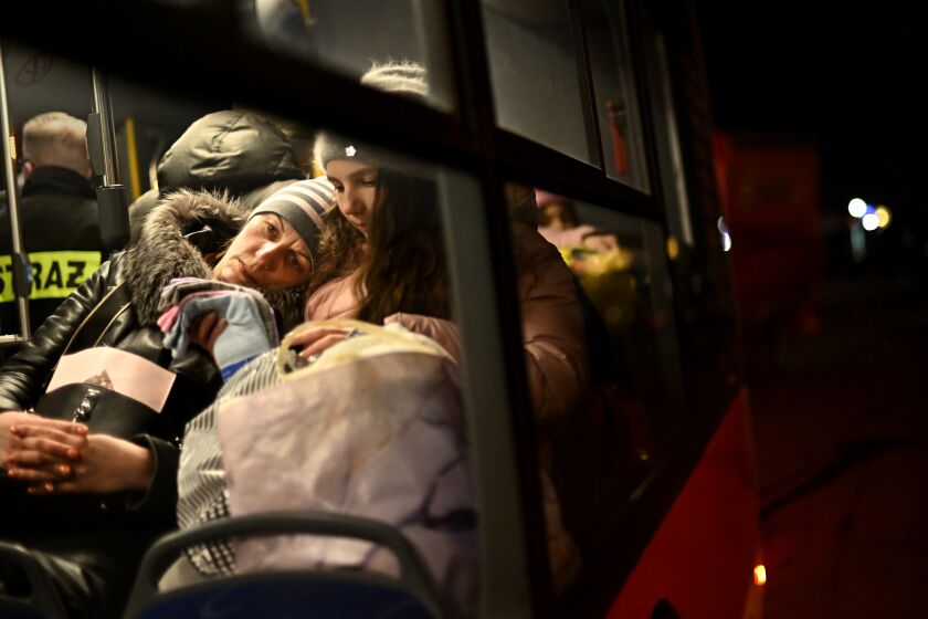Medyka, Poland Marc h 5, 2022: A mother and son wait on a bus at the border in Medyka, Poland to be taken to a safer place after crossing the border from Ukraine. (Wally Skalij/Los Angeles Times)