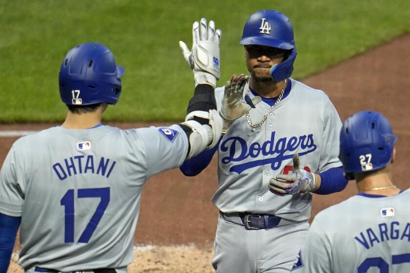 Los Angeles Dodgers' Mookie Betts is greeted by Shohei Ohtani (17) after hitting a three-run home run.