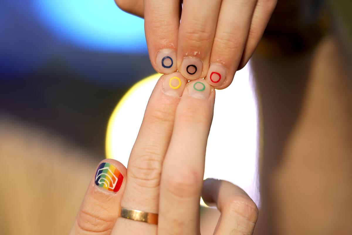 Athletes show their nails painted with the rainbow colors at Pride House, the safe space for LGBTQ+ athletes in Paris.