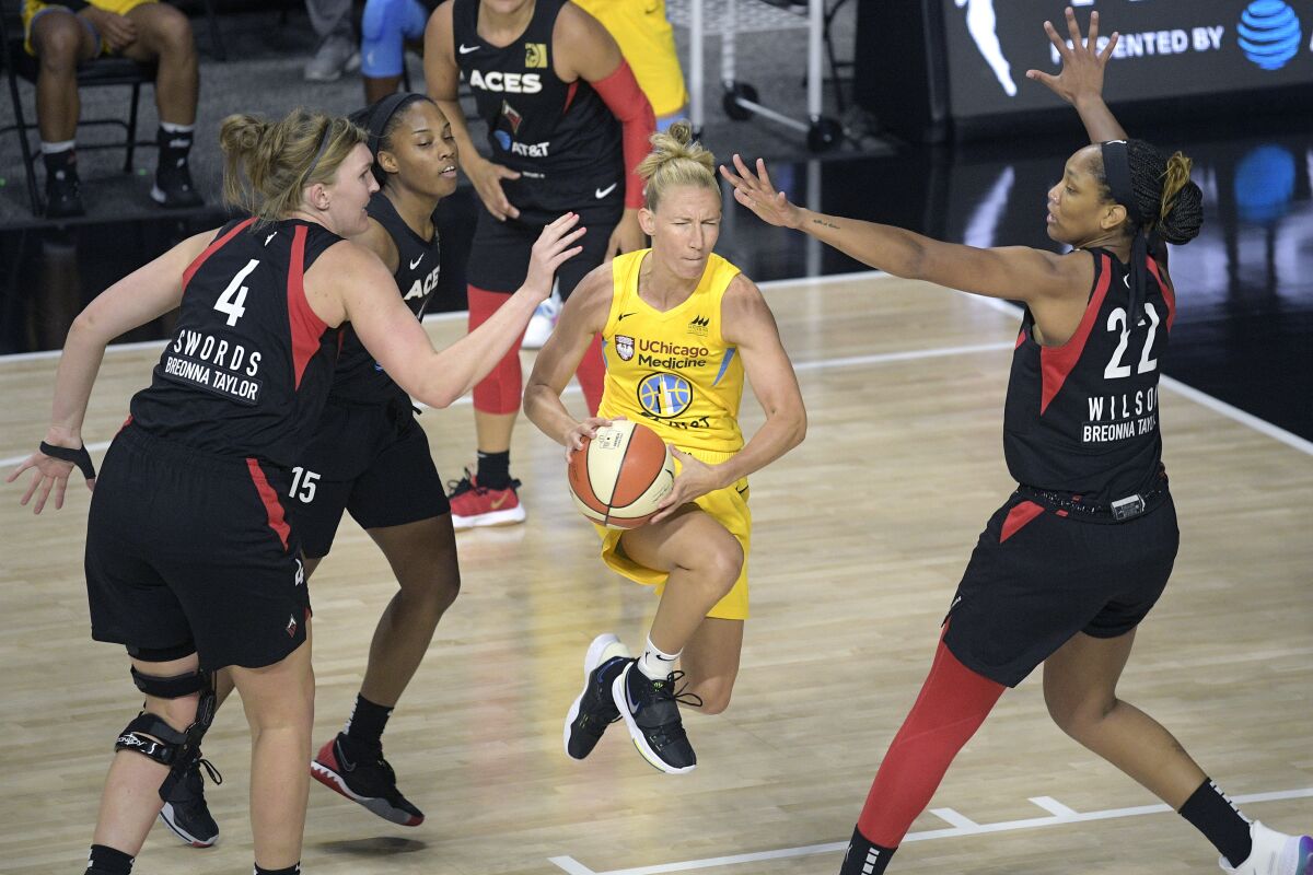 Sky guard Courtney Vandersloot drives between Aces center Carolyn Swords, guard Lindsay Allen and forward A'ja Wilson.