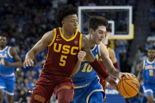 Southern California guard Boogie Ellis (5) steals the ball from UCLA guard Lazar Stefanovic.