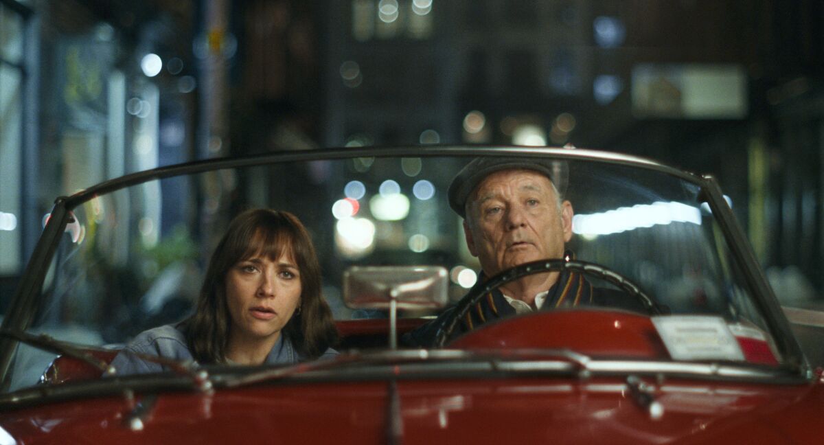 Rashida Jones and Bill Murray drive in a red sports car in the movie "On the Rocks."