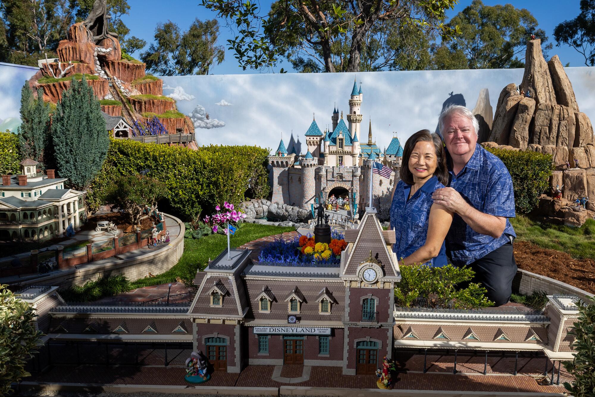 David and Frances Sheegog pose with their mini-Disneyland in their Anaheim Hills home.