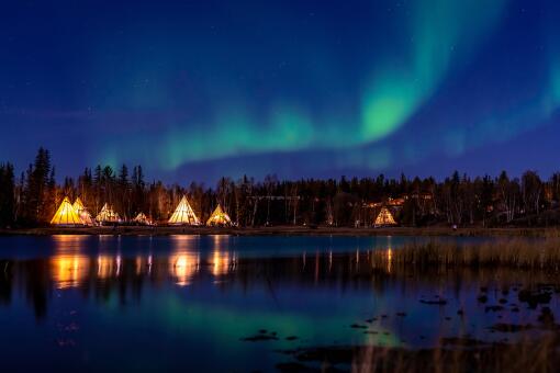 A photo of Aurora Borealis over lake at Yellow Knife, Canada.