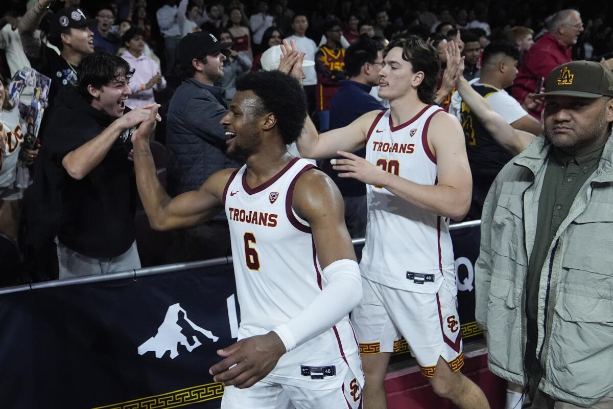 USC guard Bronny James and forward Harrison Hornery  celebrate with fans after the team's win over Arizona 