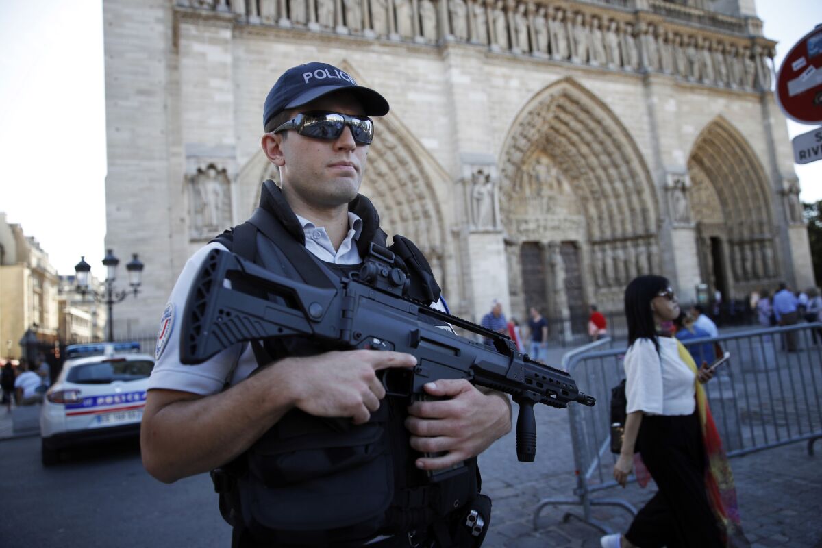 A French police officer patrols in front of Notre Dame Cathedral in Paris on Friday.