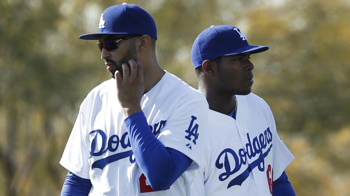 Dodgers outfielders Matt Kemp, left, and Yasiel Puig look on during a spring training practice session in February. It appears Kemp and Puig got into an argument during Monday's win over the Colorado Rockies.