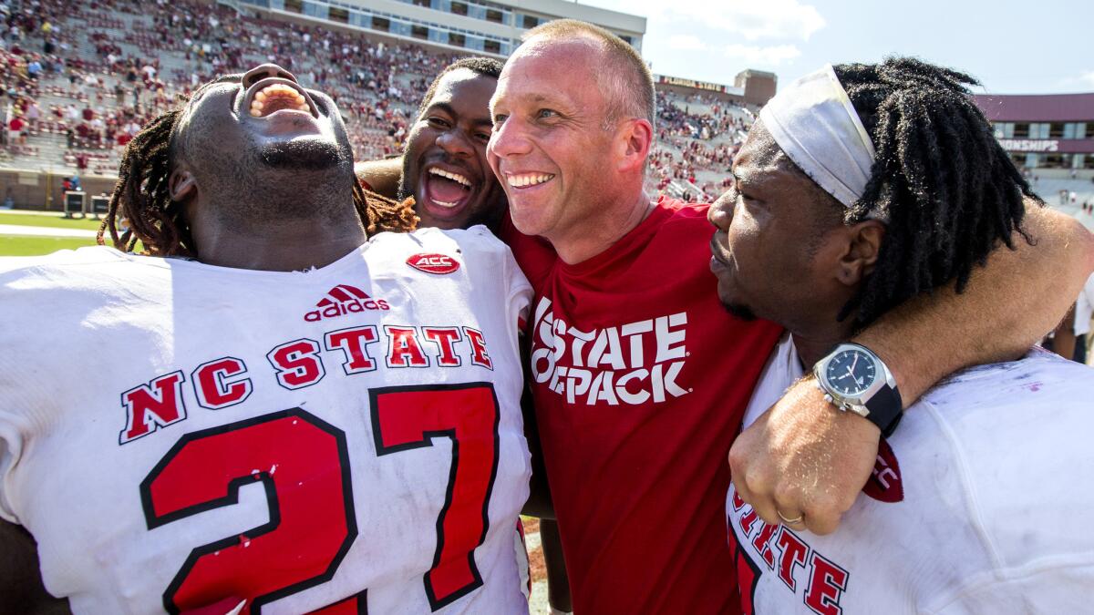 North Carolina State coach Dave Doeren celebrates with (from left) running back Dakwa Nichols (27), defensive tackle B.J. Hill, head coach Dave Doeren and linebacker Jerod Fernandez after defeating Florida State on Saturday.