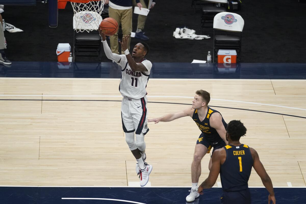 Gonzaga's Joel Ayayi shoots as West Virginia's Sean McNeil watches.