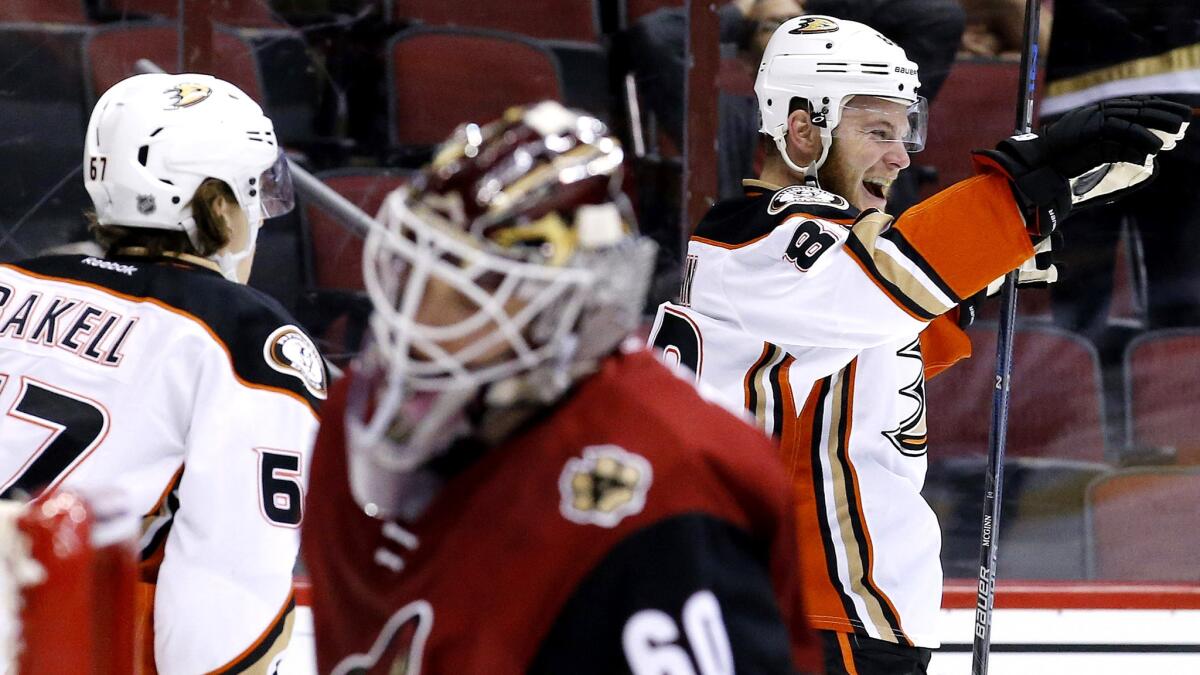 Ducks left wing Jamie McGinn, right, celebrates after scoring against Coyotes goalie Niklas Treutle (60) in the first period Thursday night.