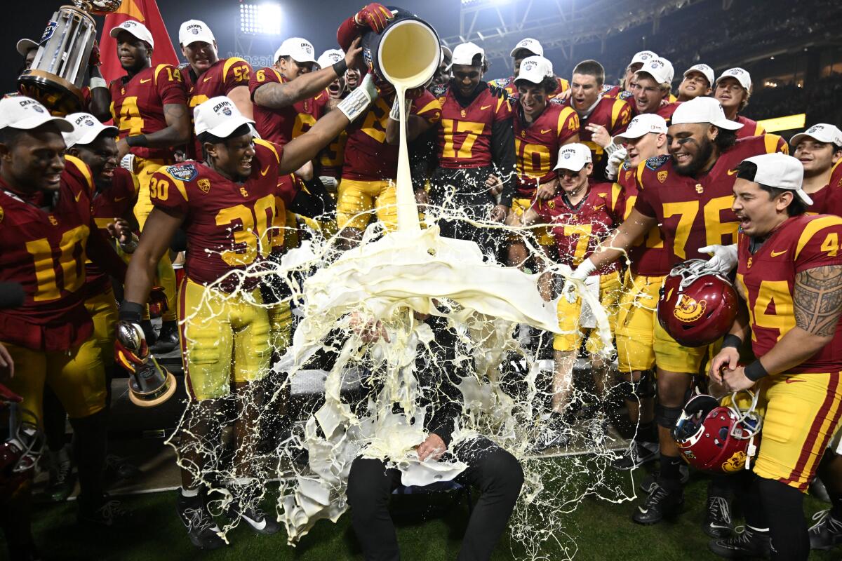 USC coach Lincoln Riley has eggnog poured onto him after the Trojans defeated Louisville during the Holiday 