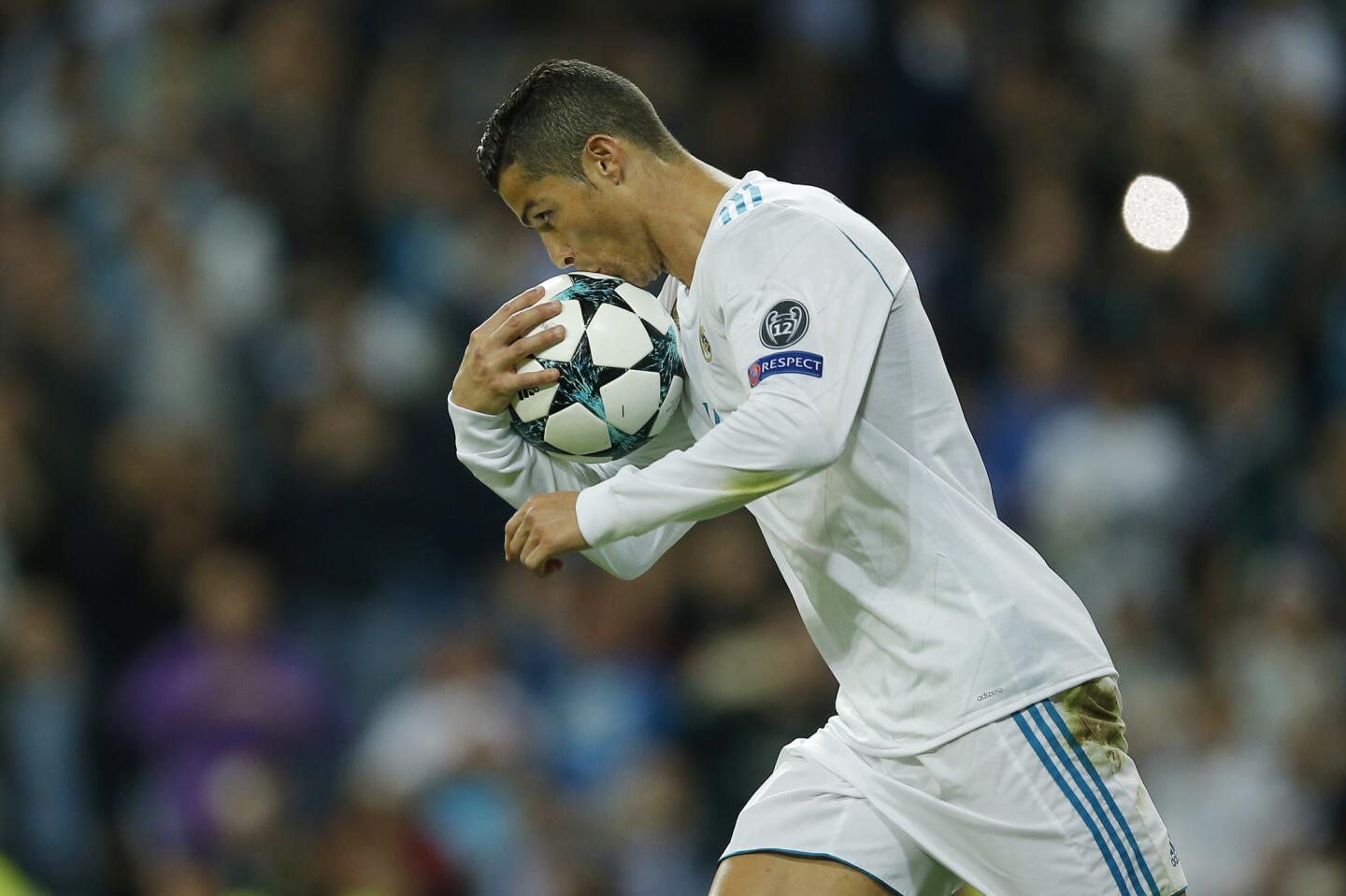 Real Madrid's Cristiano Ronaldo kisses the ball after scoring a penalty during a Group H Champions League soccer match between Real Madrid and Tottenham Hotspur at the Santiago Bernabeu stadium in Madrid, Tuesday Oct. 17, 2017. (AP Photo/Paul White)