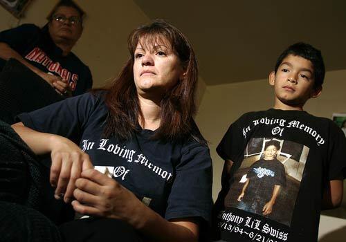 Michelle Ramirez, center, flanked by her mother Esther Esparza, 54, and her 10-year old son Christopher, says she is afraid to let her other three sons hang out outside since her 11-year old son Anthony was shot in June. The family plans to move out of the area.