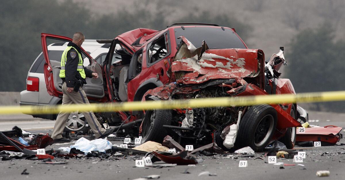 A California Highway Patrol officer examines the wreckage of a car crash on the Pomona (60) Freeway in Diamond Bar in February.