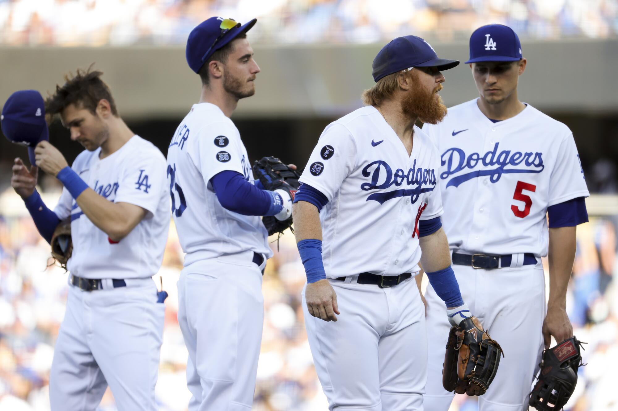 Dodgers players wait during a pitching change during the sixth inning.