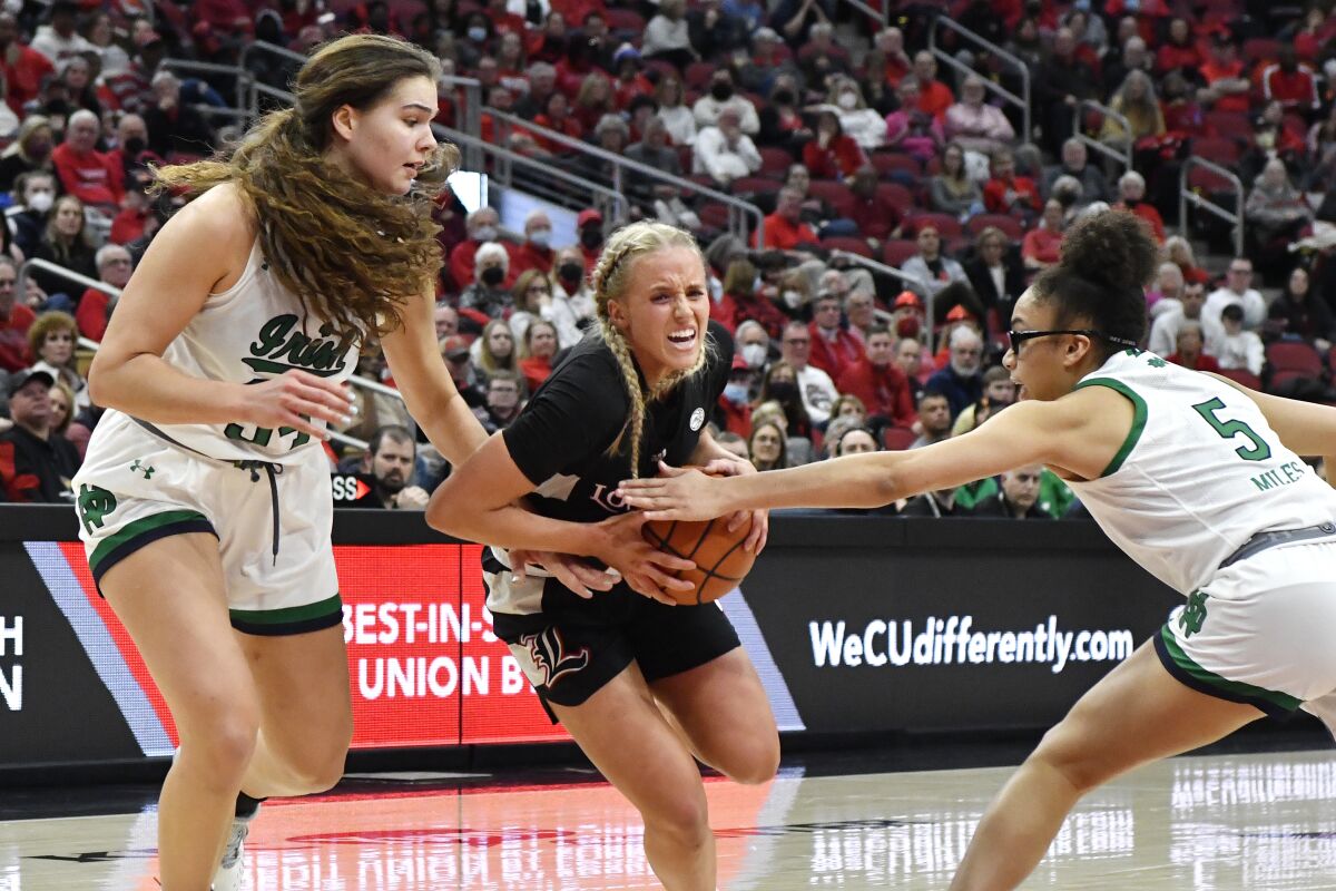 Louisville guard Hailey Van Lith, center, tries to get past Notre Dame forward Maddy Westbeld (34), left, and guard Olivia Miles (5) during the second half of an NCAA college basketball game in Louisville, Ky., Sunday, Feb. 13, 2022. (AP Photo/Timothy D. Easley)