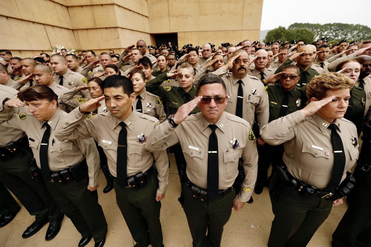 Los Angeles County sheriff's deputies salute during funeral services held for Deputy Joseph Solano on Monday morning at the Cathedral of Our Lady of the Angeles in downtown Los Angeles.