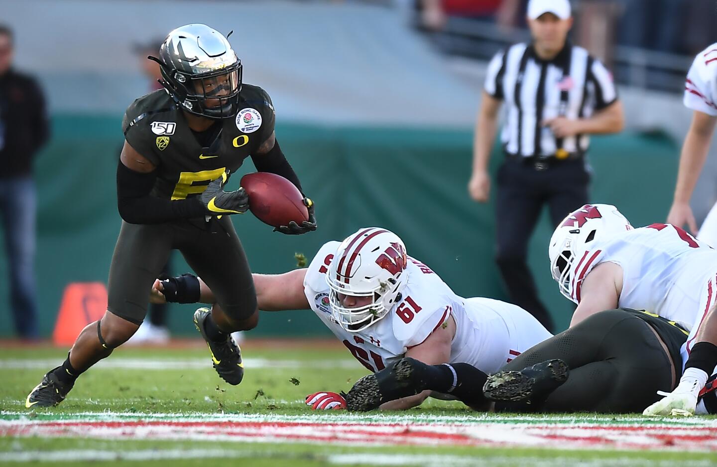 Oregon cornerback Deommodore Lenoir picks up a fumble against Wisconsin in the second quarter.
