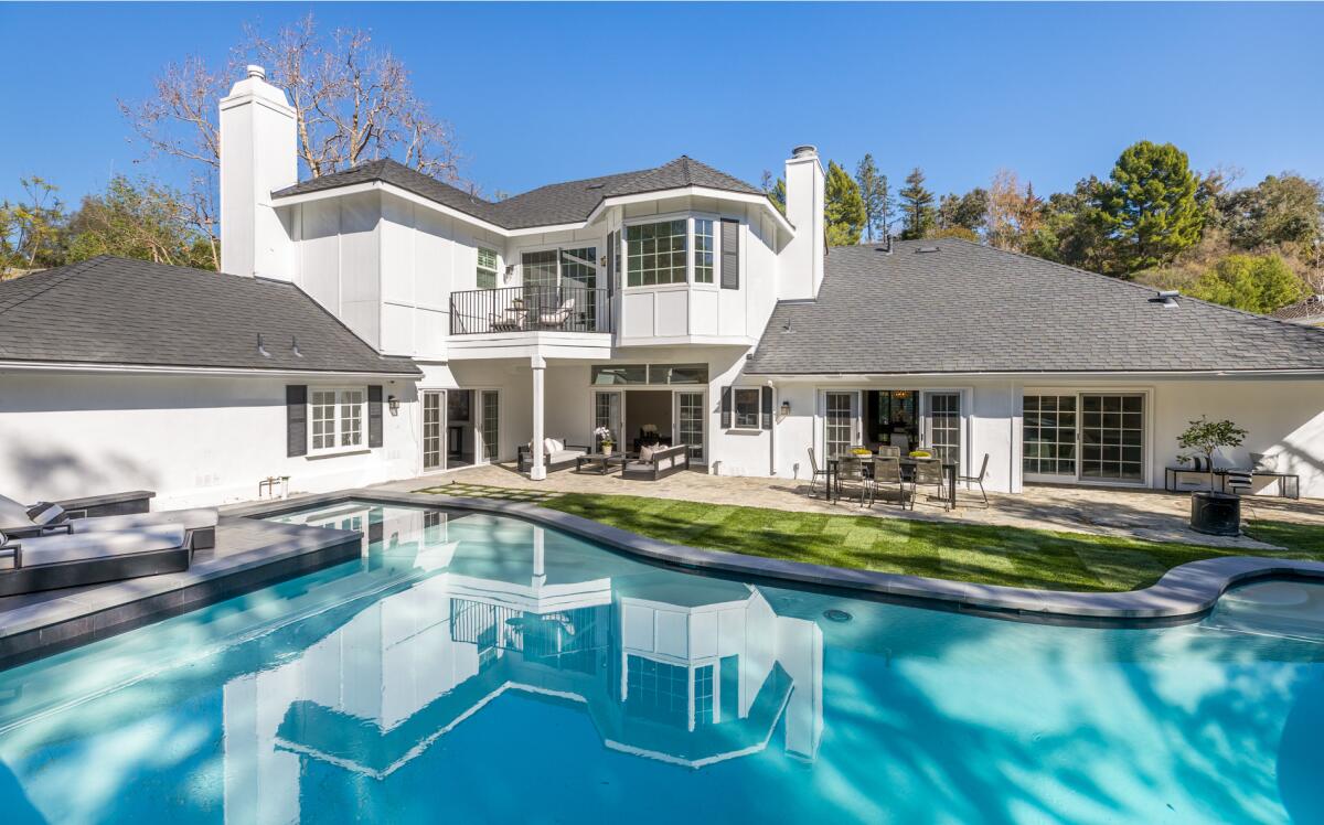 The Hamptons-style traditional makes the most of its space with a gated motor court in front and a pool in back.