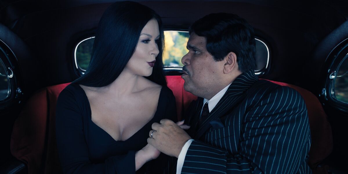 Un marido y una mujer vestidos de negro en el asiento trasero de un coche.