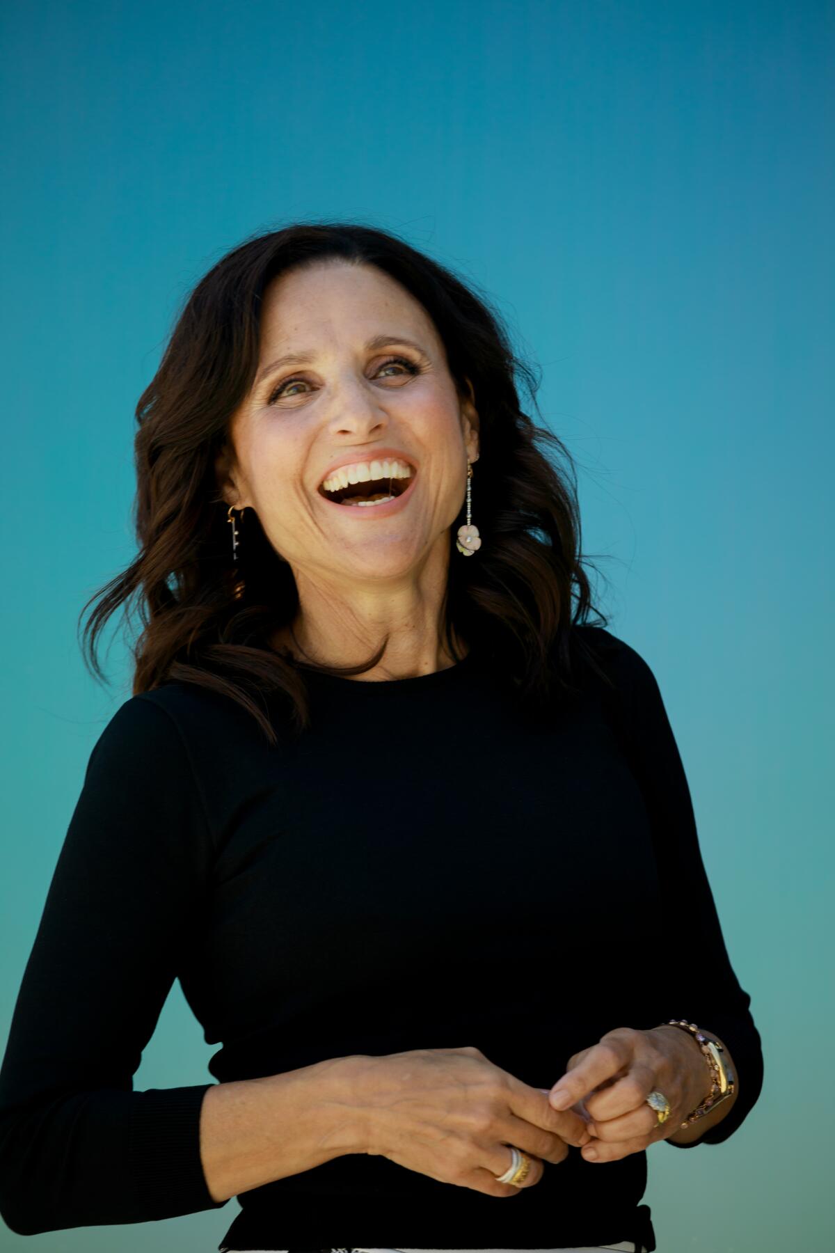 Julia Louis-Dreyfus laughs as she poses for a photo