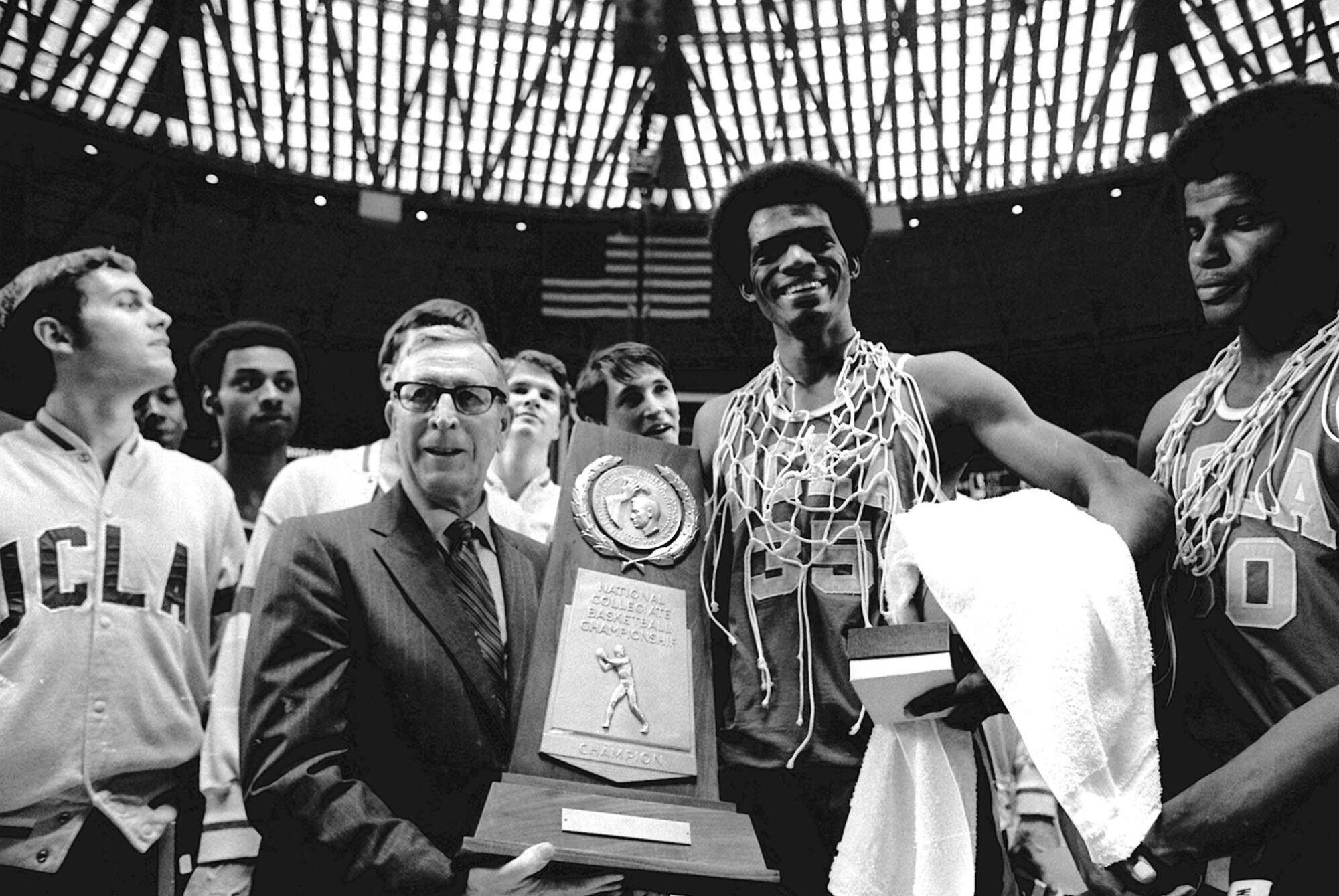 UCLA basketball coach John Wooden celebrates with Sidney Wicks and other UCLA players.