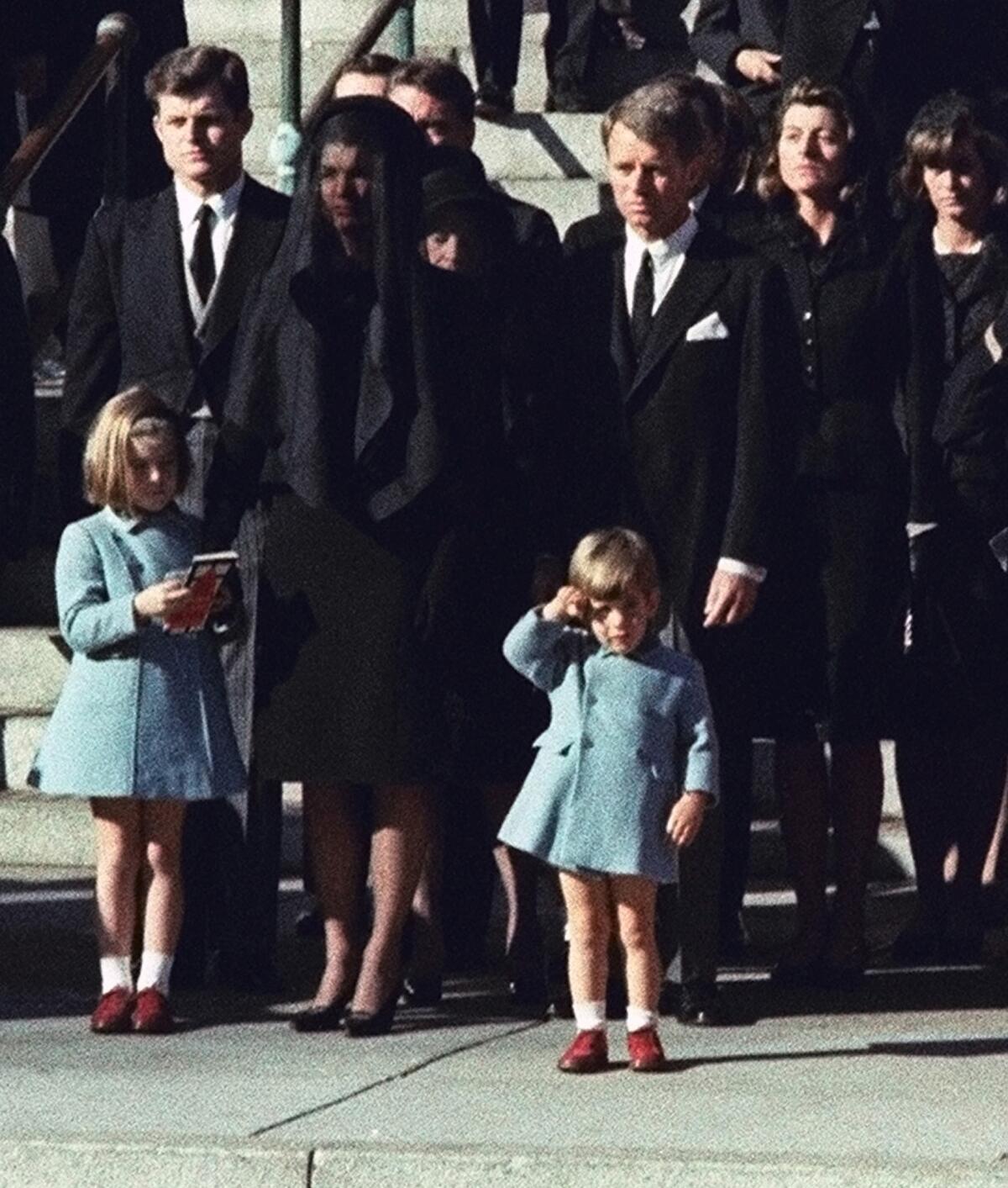 Three-year-old John F. Kennedy Jr. salutes his father's casket as it passes on a horse-drawn caisson during funeral ceremonies in Washington on Nov. 25, 1963. Behind John Jr. stands his uncle Robert F. Kennedy, mother Jacqueline Kennedy, uncle Edward M. Kennedy and sister Caroline Kennedy.