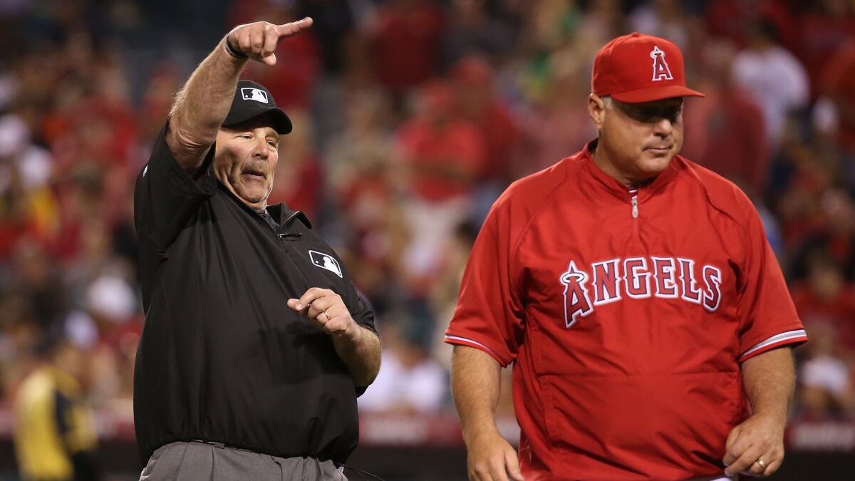 First base umpire Bob Davidson ejects Angels Manager Mike Scioscia during the fifth inning of the team's 4-1 win over the Oakland Athletics on Monday.