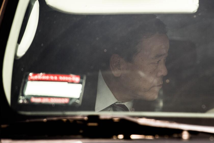 Former LASD Undersheriff Paul Tanaka avoids media as he leaves the federal courthouse in Los Angeles after being found guilty of corruption charges on April 6.