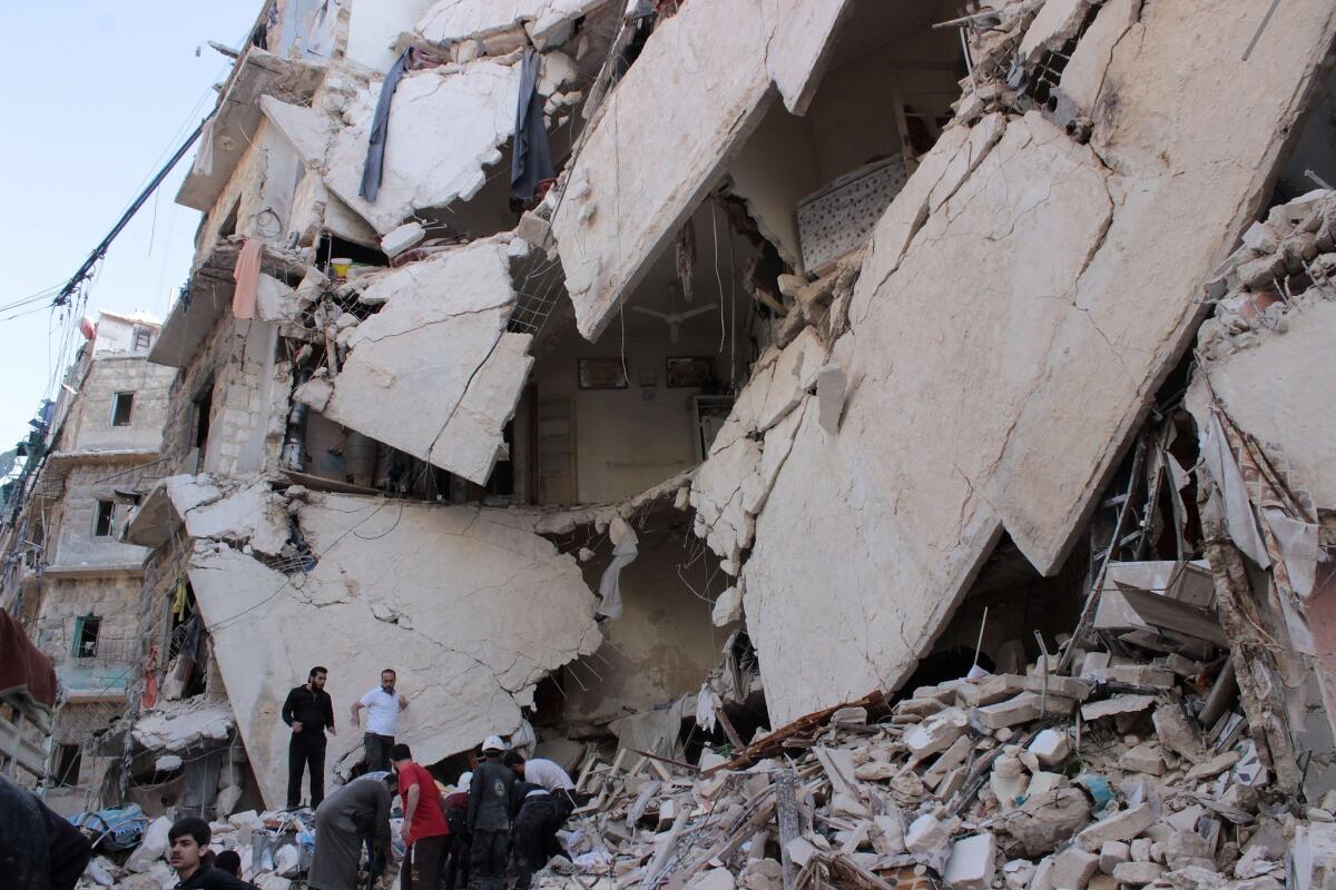 Syrian rescue workers and civilians inspect the rubble after an airstrike, reportedly by government forces, on the rebel-held Bustan Qasr neighborhood of Aleppo.