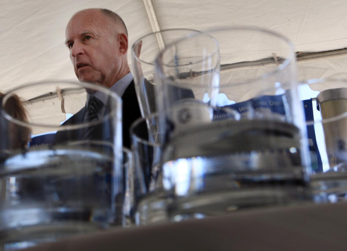 Gov. Jerry Brown, pictured here last year with glasses of reclaimed water in Orange County, wants to change a 1996 ballot initiative that has limited his efforts to tackle the drought.