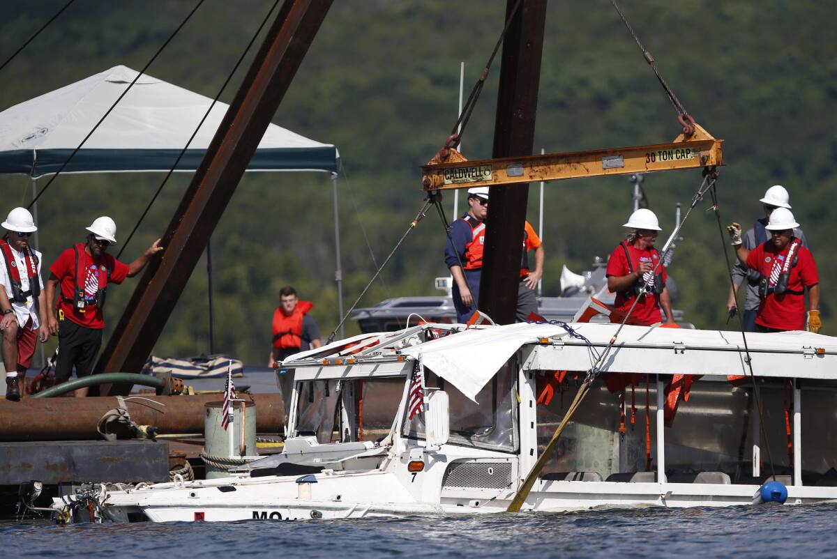 FILE - In this July 23, 2018 file photo, a duck boat that sank in Table Rock Lake in Branson, Mo., is raised after it went down the evening of July 19 after a thunderstorm generated near-hurricane strength winds, killing 17 people. A county prosecutor and Missouri Attorney General Eric Schmitt filed state charges, Friday, July 16, 2021, against three employees of the duck boat tourist attraction in connection with the boat sinking. (Nathan Papes/The Springfield News-Leader via AP)