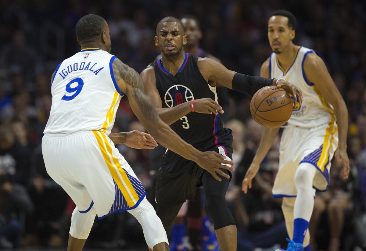 Clippers guard Chris Paul dribbles around Golden State forward Andre Iguodala during a Feb. 20 game at Staples Center.