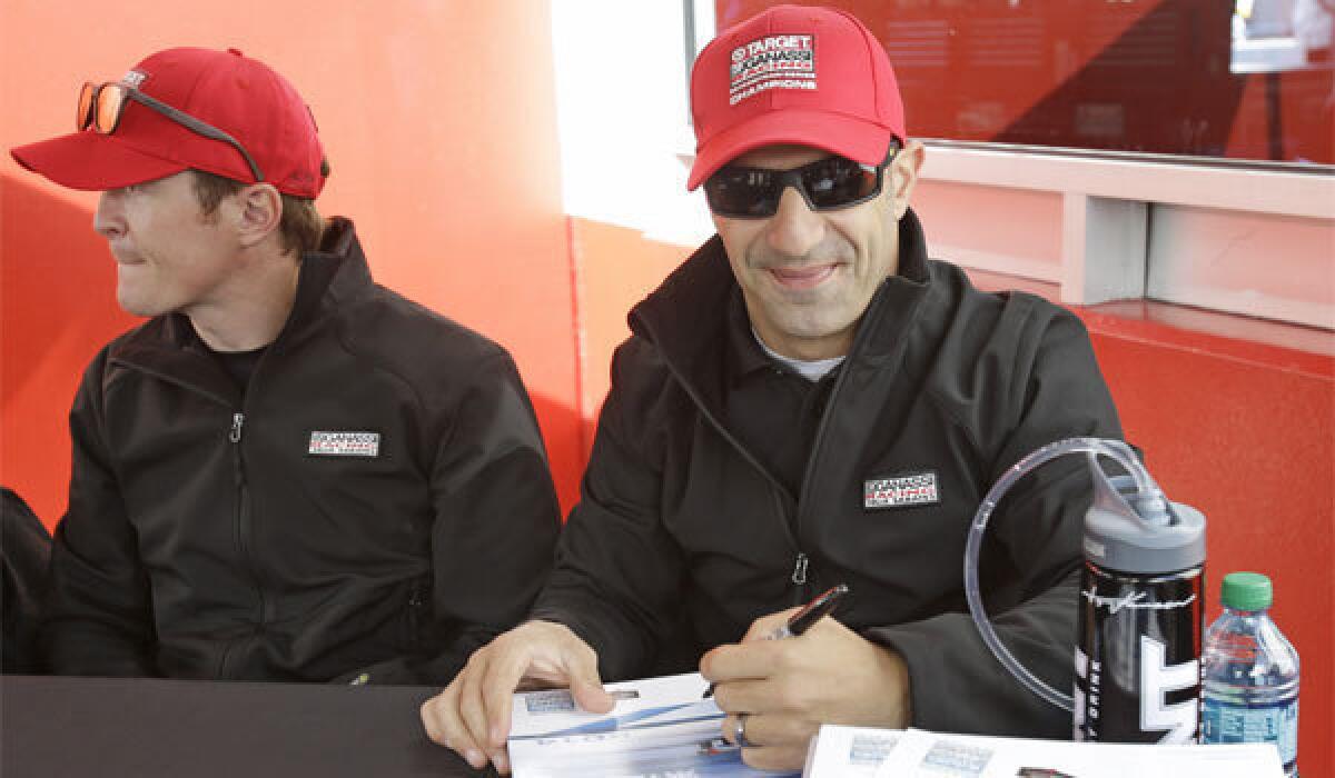 Scott Dixon, left, and Tony Kanaan sign autographs prior to the Rolex 24 race Jan. 25 at Daytona International Speedway. Both drivers are tentatively scheduled to participate in a day-long test session next Monday at Auto Club Speedway in Fontana to prepare for the MAVTV 500 there on Aug. 30. The session is open to the public.