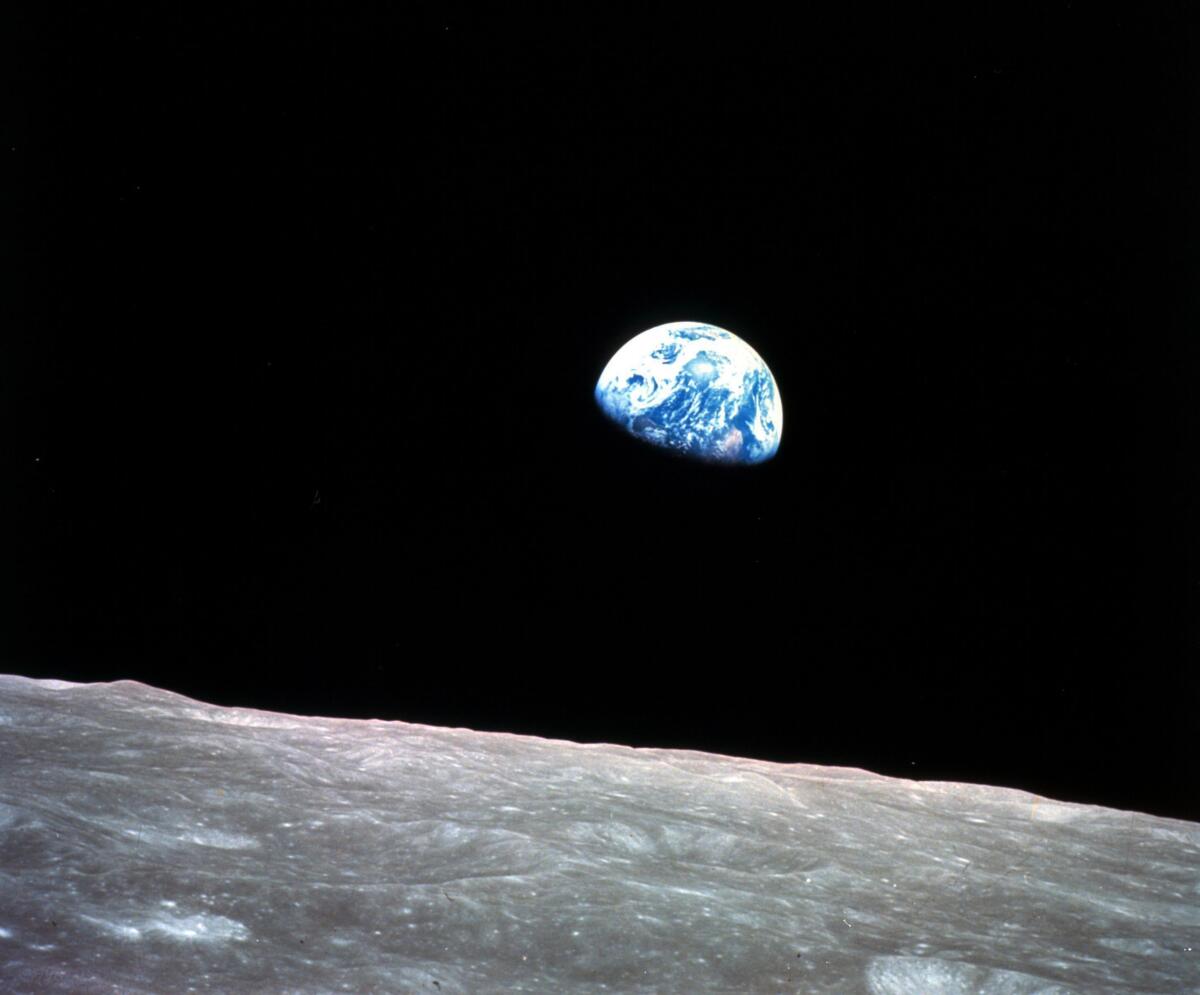 The Earth behind the surface of the moon during the Apollo 8 mission.