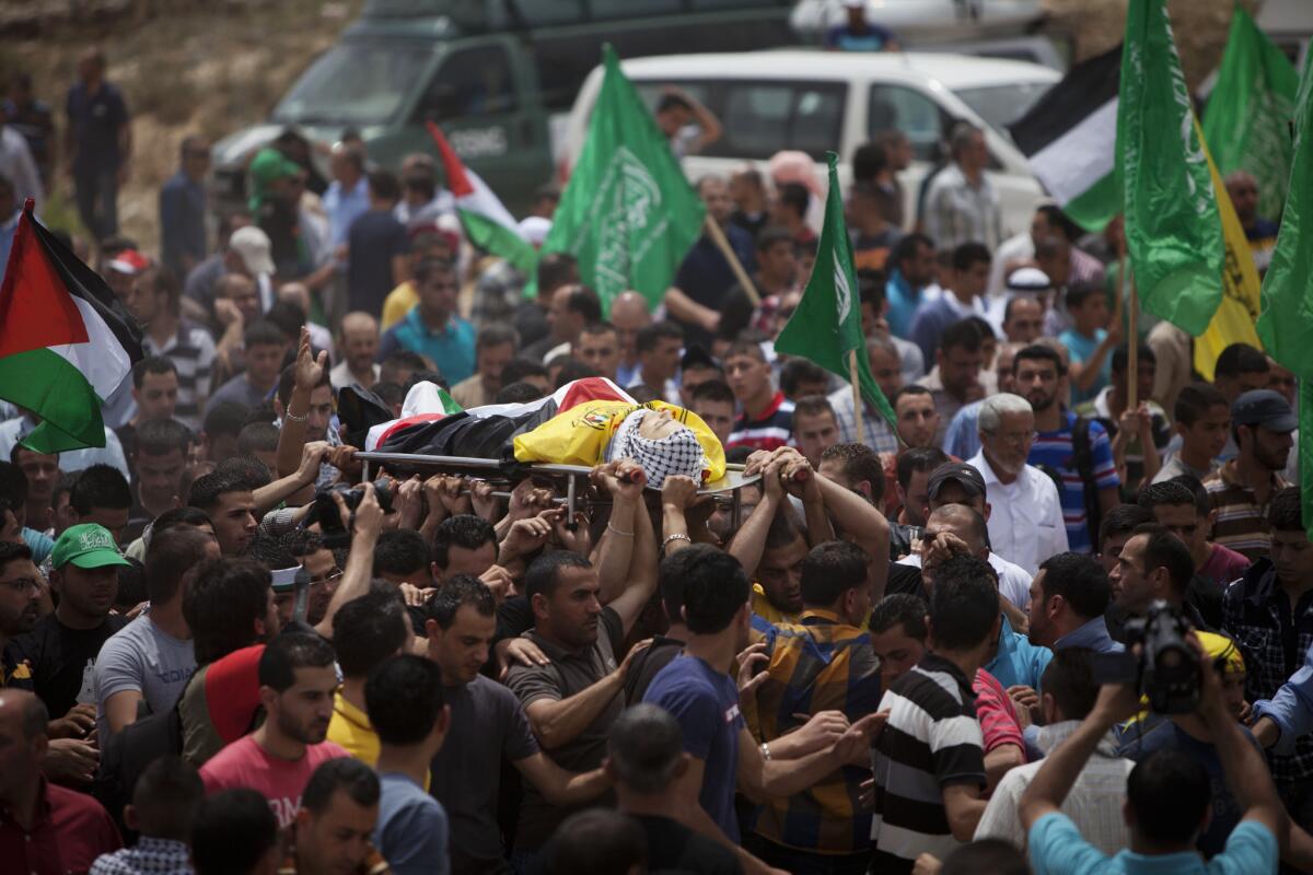Members of the Palestinian national security forces carry the body of Nadim Nowarra, who was killed in a clash with Israeli troops on May 15, during a funeral the following day in the West Bank city of Ramallah.